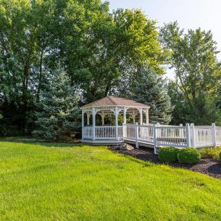 A beautiful gazebo surrounded by lush greenery and a well-maintained lawn.