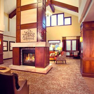A cozy living room with a central fireplace, featuring modern design elements and high ceilings.