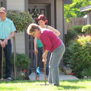 A group of people playing croquet in a garden.