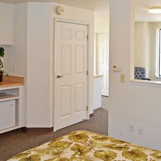 A minimalist bedroom interior with a focus on natural light and neutral decor.