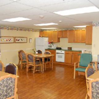 A communal kitchen and dining area with wooden furniture and appliances.