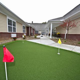 A residential courtyard featuring a putting green with colored flags.