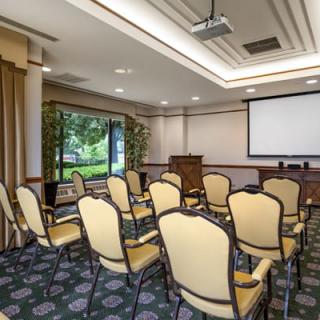 A small conference room set up for a meeting with chairs facing a projector screen.