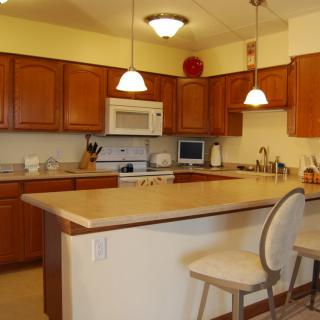 A cozy kitchen with wooden cabinets and a central island with seating.