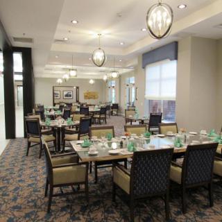 A well-lit dining room with neatly arranged tables and chairs.