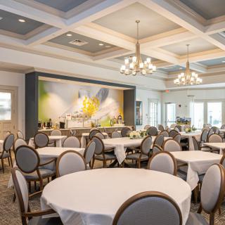 An elegant banquet hall with round tables and chandeliers, set up for an event.