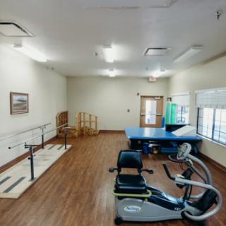 A rehabilitation room equipped with exercise machines and therapy tools.