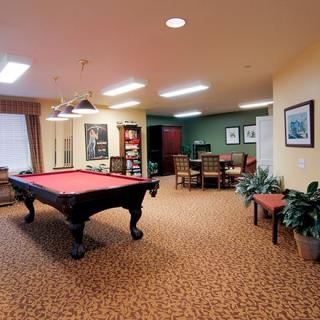 A cozy game room featuring a billiards table and seating area.