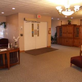 A cozy lobby area with seating and a wooden cabinet.