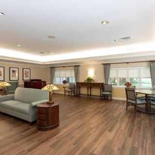 A spacious living room with wooden flooring, comfortable sofas, and elegant decor.