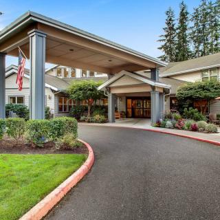 A welcoming building entrance with a covered driveway and well-maintained landscaping.
