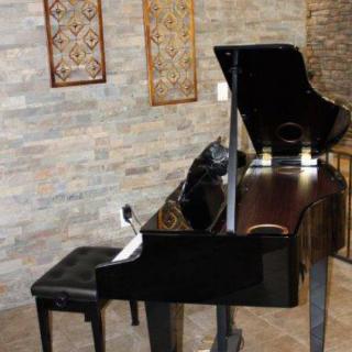 A grand piano in a beautifully decorated interior with brick walls.