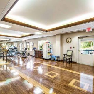 A spacious rehabilitation center equipped with exercise machines and well-lit areas for patient activities.