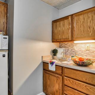A cozy kitchen corner with wooden cabinets and a countertop featuring a fruit bowl.