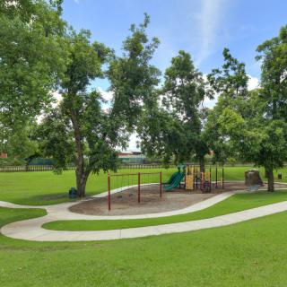 A scenic view of a playground surrounded by lush greenery and winding pathways.
