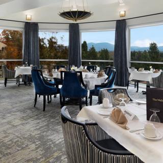 Elegant dining room with panoramic window views and sophisticated table settings.
