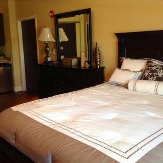 A cozy bedroom with a neatly made bed and elegant decor.