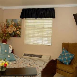 A cozy living room with a sofa, armchair, and decorative cushions.