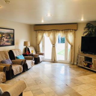 A cozy living room with comfortable seating, a large TV, and elegant curtains.