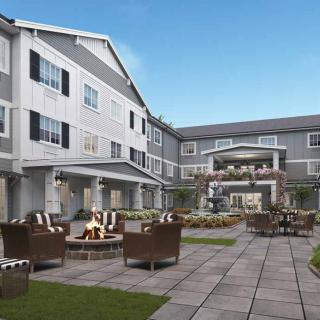 A modern residential building with a well-furnished courtyard featuring outdoor seating.
