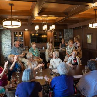 A joyful gathering of friends enjoying a social event in a cozy restaurant setting.