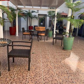 A tranquil outdoor patio with tables and chairs surrounded by potted plants.