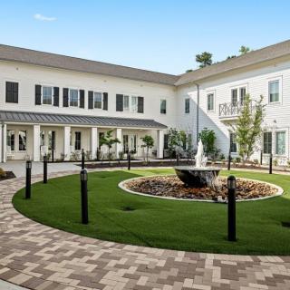 A landscaped courtyard with a central fountain surrounded by a well-maintained building.