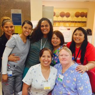 A cheerful group of healthcare professionals posing together in a hospital setting.