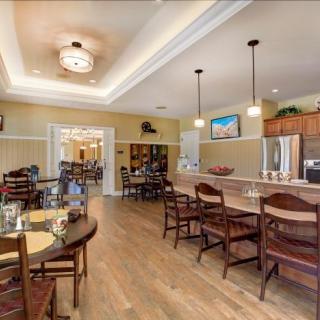 A modern kitchen and dining area with a bar counter and pendant lighting.