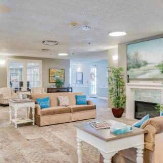A cozy and modern living room featuring comfortable sofas, a stylish coffee table, and a fireplace adorned with artwork.