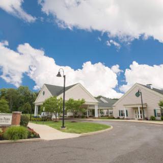 A serene view of a building with a clear blue sky and fluffy clouds.