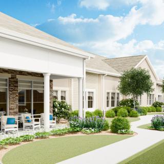 A well-maintained residential building with a garden and pathway under a clear blue sky.