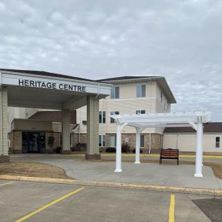 The entrance of a building labeled 'Heritage Centre' under a cloudy sky.