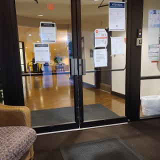 View of the entrance with glass doors leading into a spacious interior, decorated with signage.