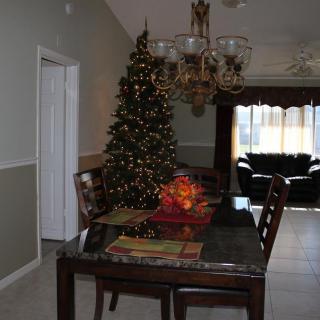 A cozy dining room adorned with a decorated Christmas tree and festive table setting.