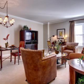 A cozy living room with a connected dining area featuring elegant furniture and warm lighting.