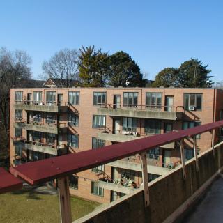 A view of a multi-story apartment building with balconies on a clear day.