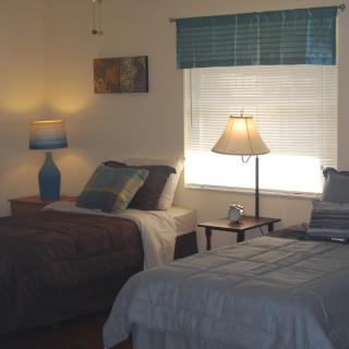 A cozy bedroom with two twin beds and warm lighting from lamps.