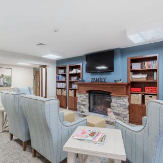 A cozy living room with a fireplace, bookshelves, and comfortable seating.
