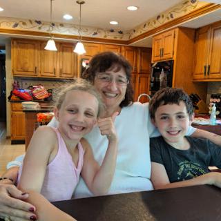 A joyful moment captured with a grandmother and her grandchildren in the kitchen.