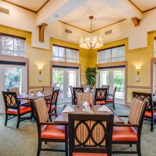 A well-lit dining area with elegantly arranged tables and chairs, showcasing sophisticated interior design.