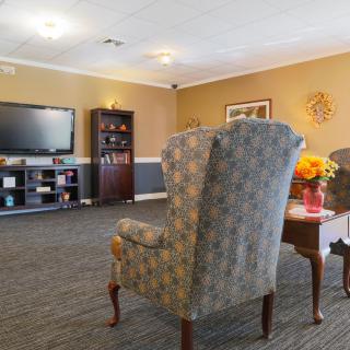 A cozy living room with an armchair, television, and decorative elements.