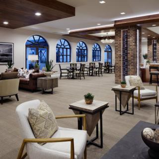 A modern lounge area with comfortable seating and large windows.