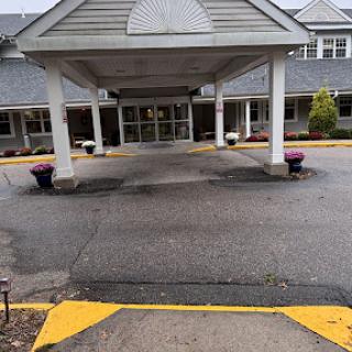 The entrance to a commercial building featuring a covered walkway and planters.