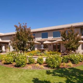 A beautiful residential building with a landscaped garden under a clear blue sky.