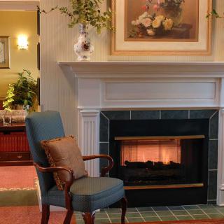 A cozy living room with an elegant fireplace and a comfortable chair.