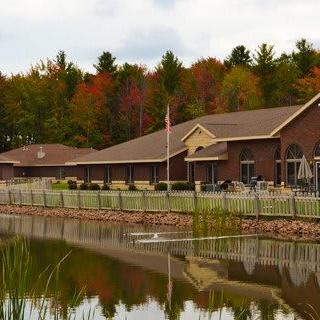 A lakeside building surrounded by autumn trees with reflections in the water.