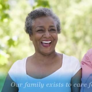 A smiling elderly woman enjoying a moment outdoors with a care message.