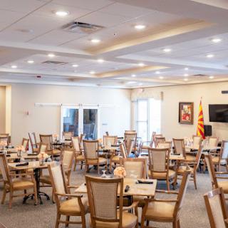 A well-lit dining area with neatly arranged tables and chairs.