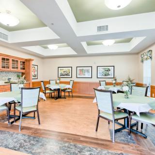 A bright and spacious dining room with neatly arranged tables and chairs.